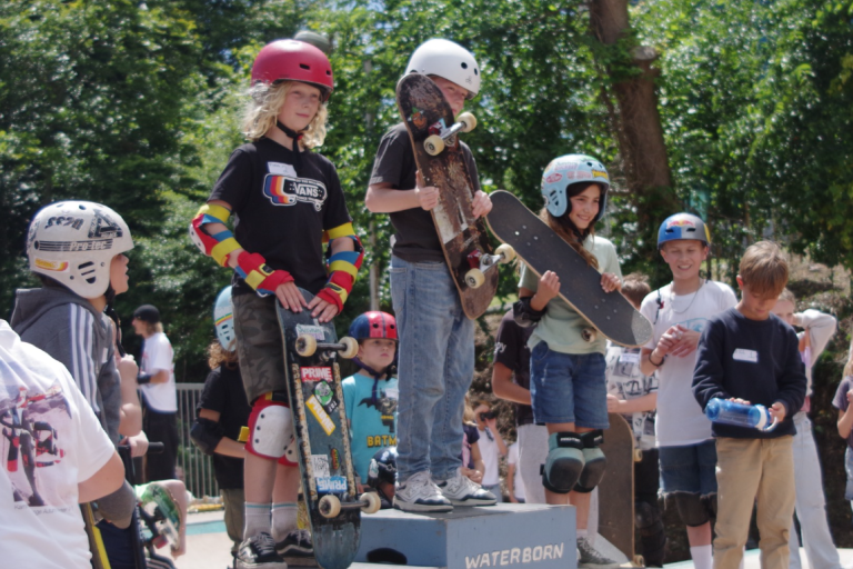 Children on podium with skateboards receiving their results