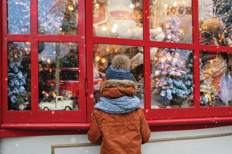 boy looking into christmas themed shop window