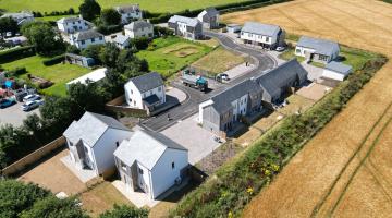 An aerial shot of Holywell Meadow, the new housing development on the edge of St Ann's Chapel. The development is surrounded by lush green fields and the houses look modern and bright.