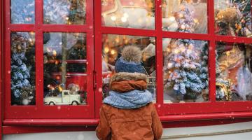 boy looking into christmas themed shop window