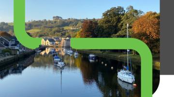 a green logo running through a river scene